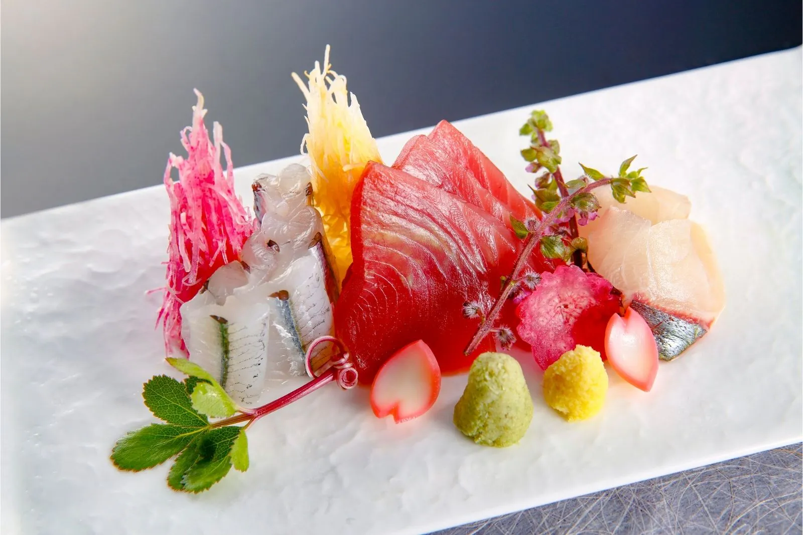 Artfully plated assorted premium sashimi garnished with edible flowers and fresh herbs at SUSHI 88, a Japanese Restaurant in New York