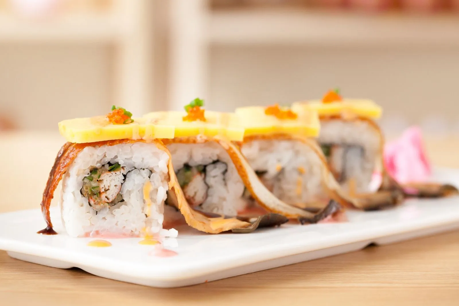 Grilled eel sushi rolls topped with tamago, fish roe and light sauce drizzle at SUSHI 88, a Japanese Restaurant in New York